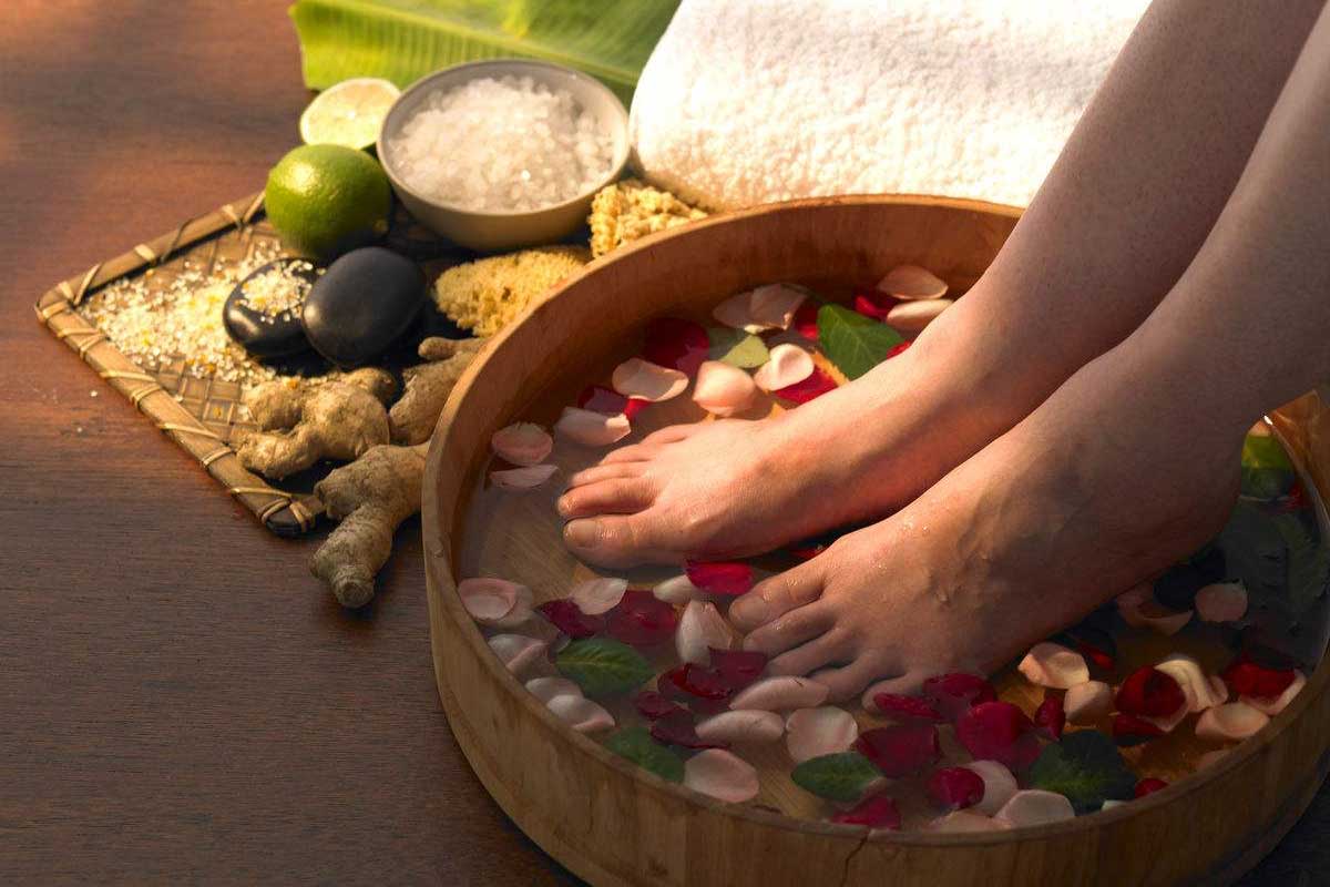 Discerning guests enjoying a hot herbal foot soak session inside a luxury spa suite.