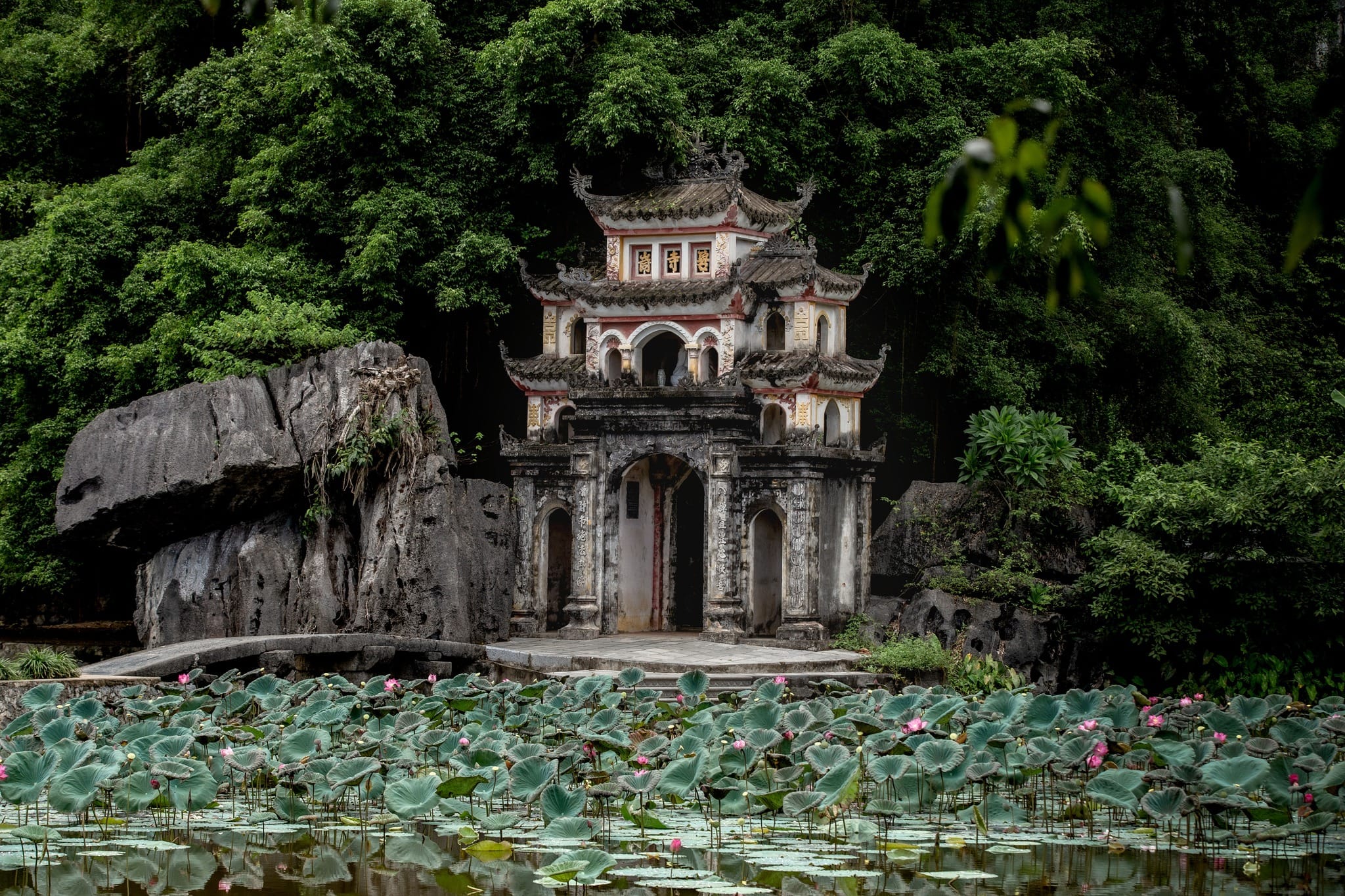 Photographing ancient, moss-covered stone bridges at a leading cultural sanctuary for couples travel vietnam.