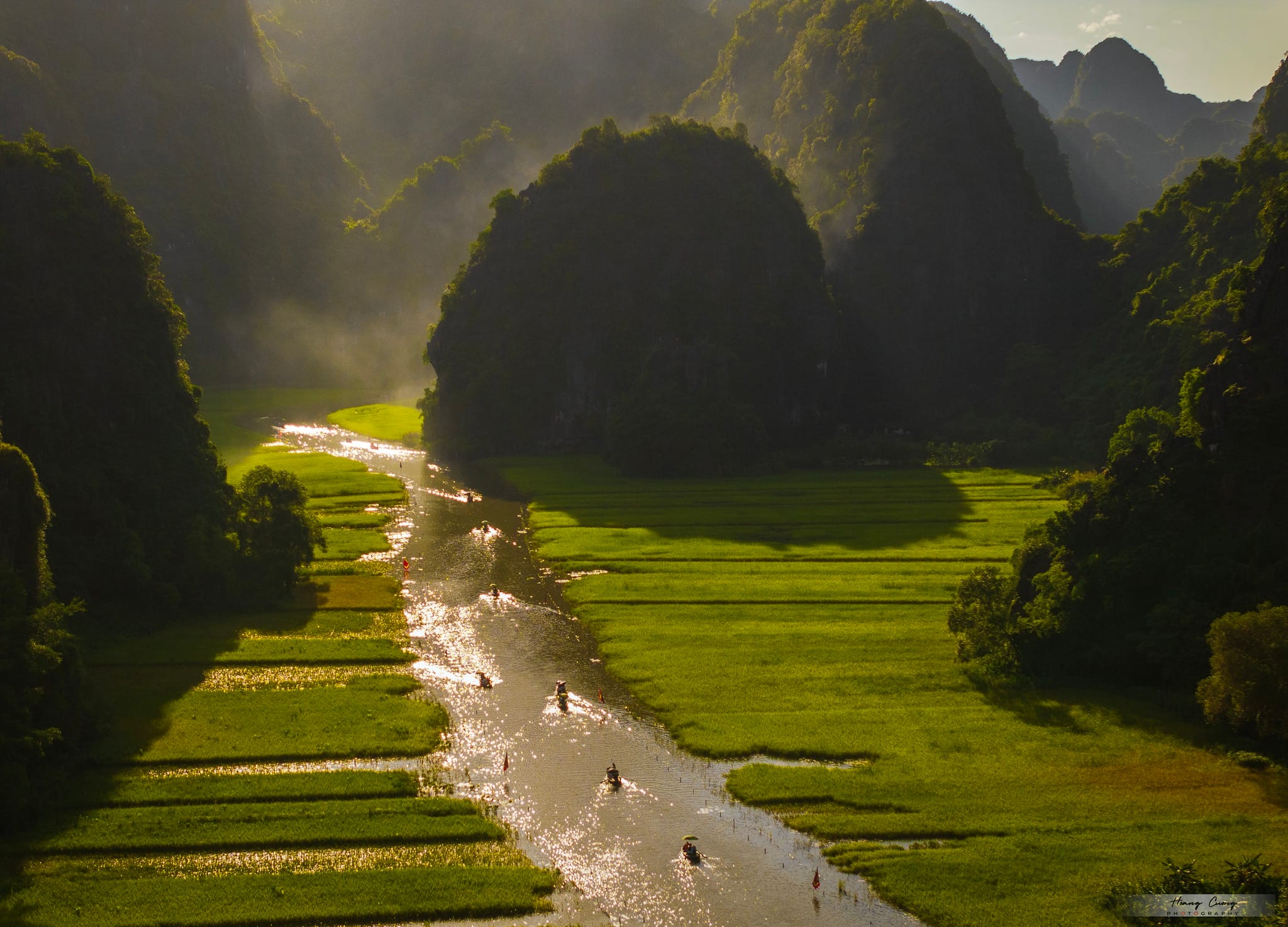 A breathtaking wide shot of the morning sun illuminating the dramatic, steep limestone valleys below the summit