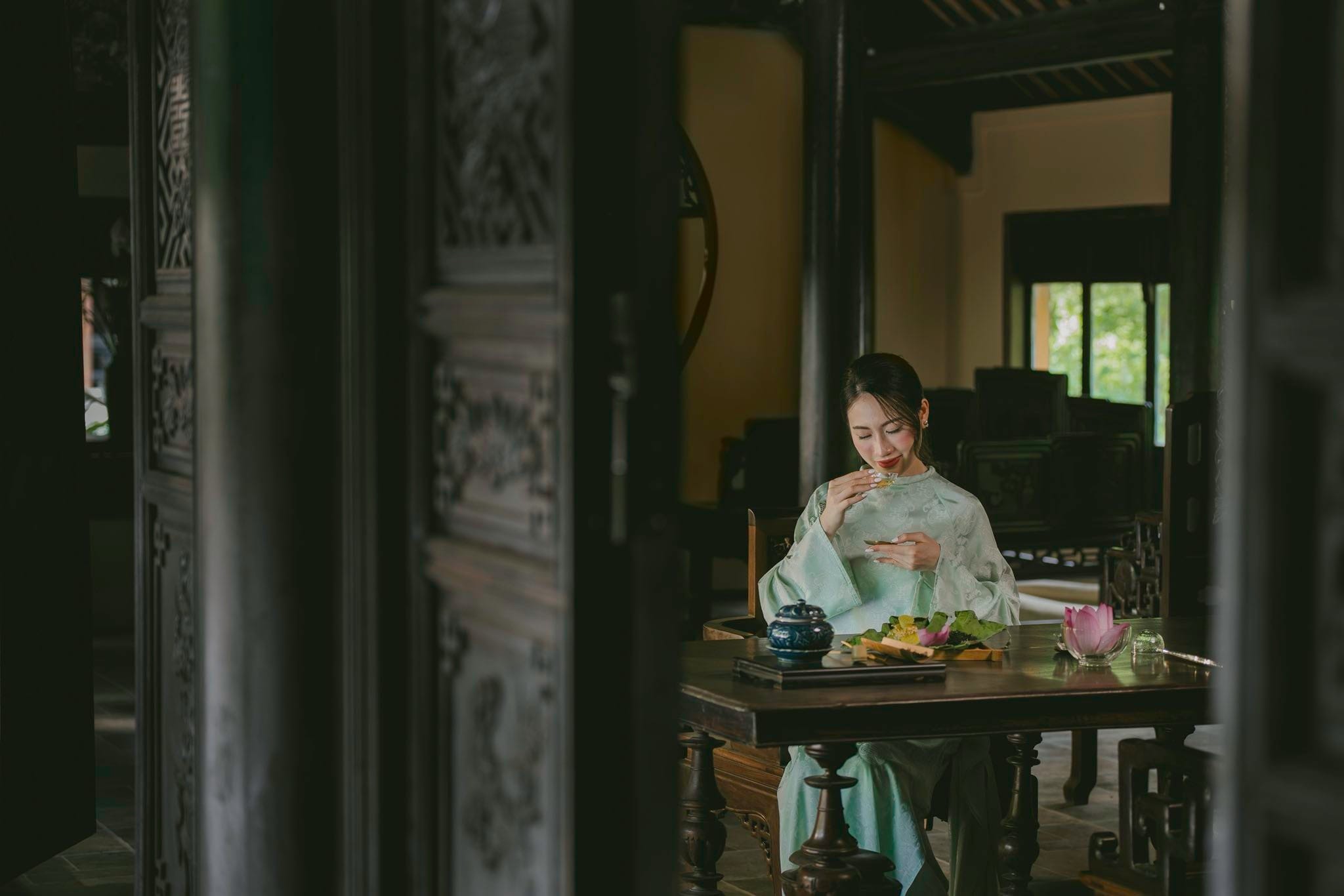 A traveler relaxing in a luxurious river-view accommodation, immersed in the peaceful countryside atmosphere