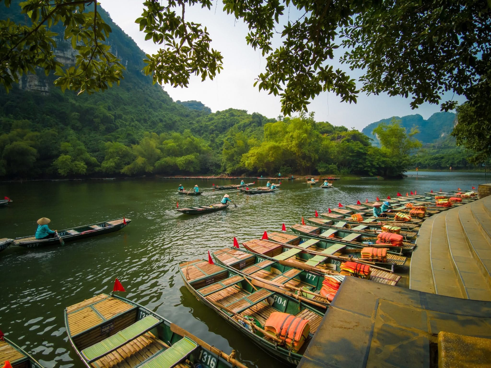 A serene boat journey through the majestic limestone karsts and waterways of the Trang An Landscape Complex, located near Hoa Lư Ancient Capital