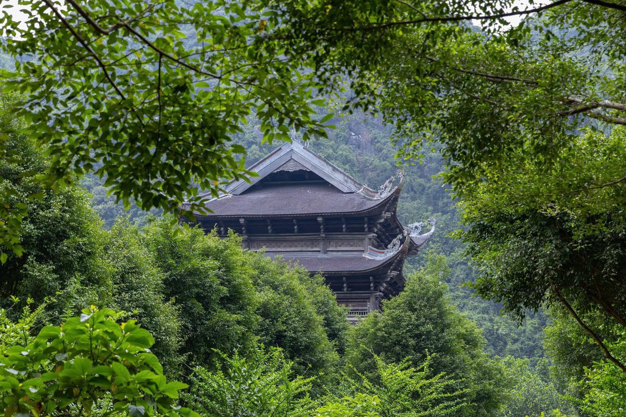 A tranquil, picturesque scene of the temple and its reflection on the water, highlighting the beauty of Trang An Ninh Binh.
