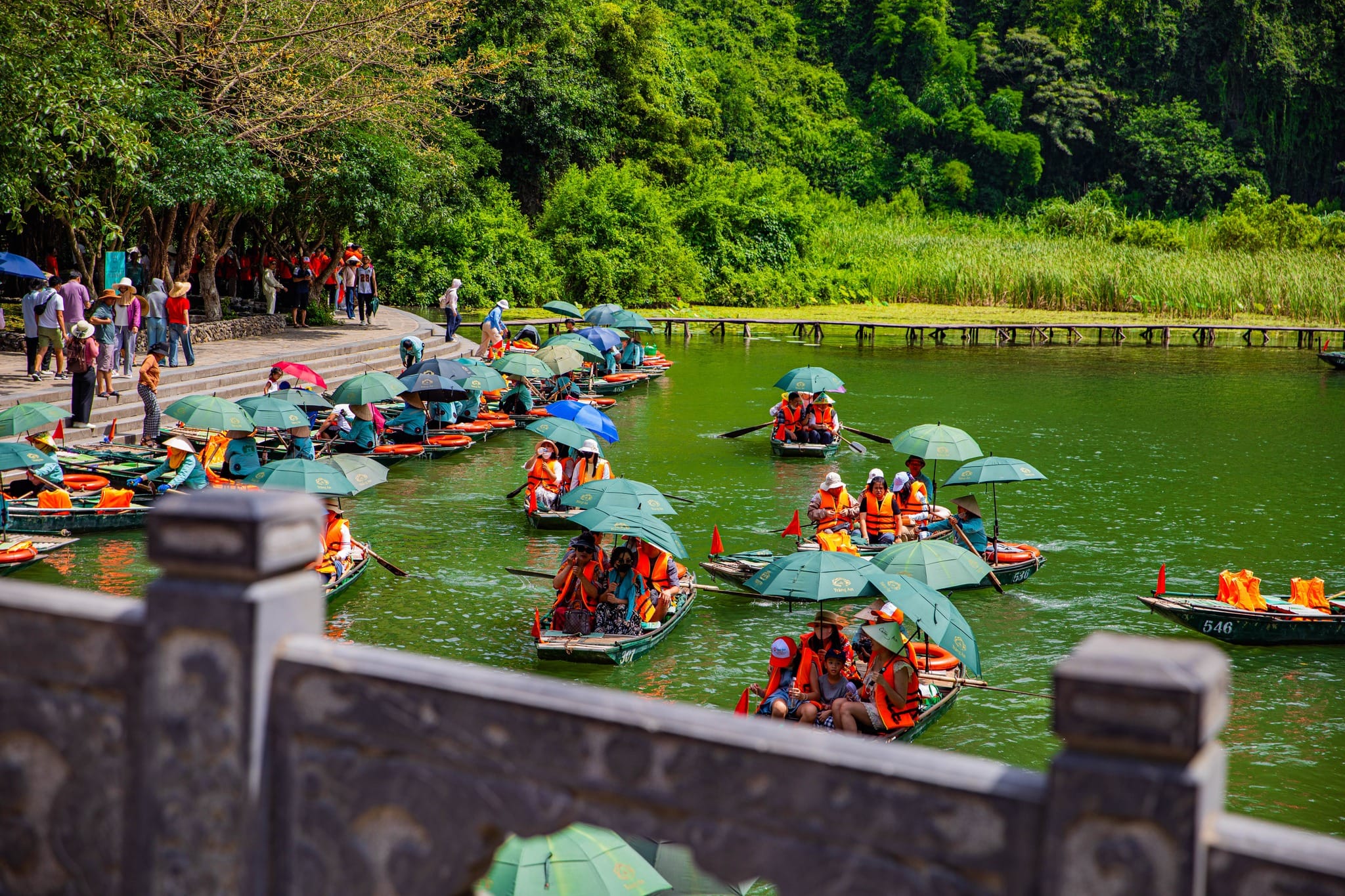 Boats docked near the temple, connecting visitors to the geographical origins and myths of the Trang An Ninh Binh area.