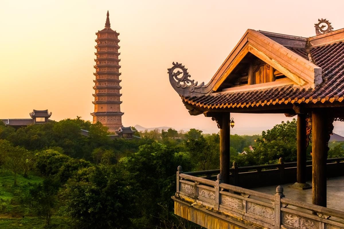 The lush green landscape and peaceful water features surrounding the massive architectural structures