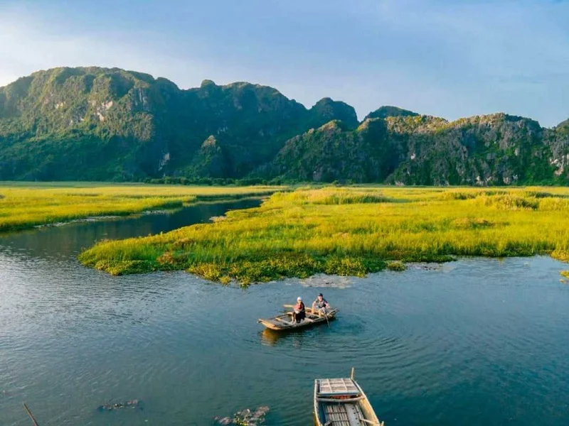 Gliding silently across mirror-smooth waters at the top eco-sanctuary among ninh binh hidden gems.