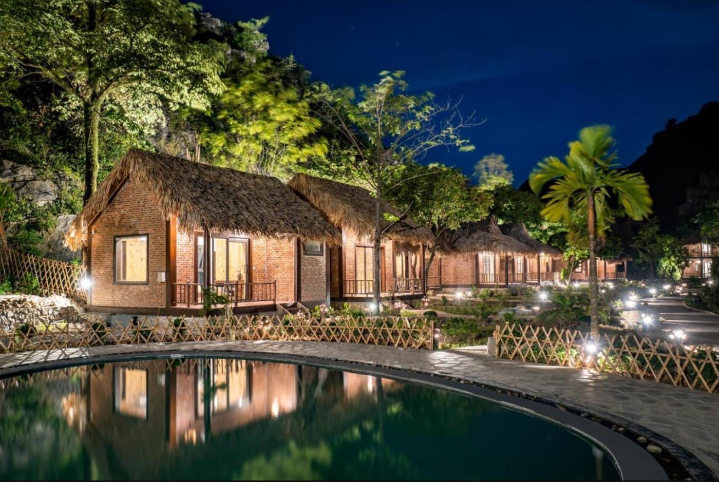 A sophisticated swimming pool area framed by the iconic vertical peaks of the Ninh Binh valley.